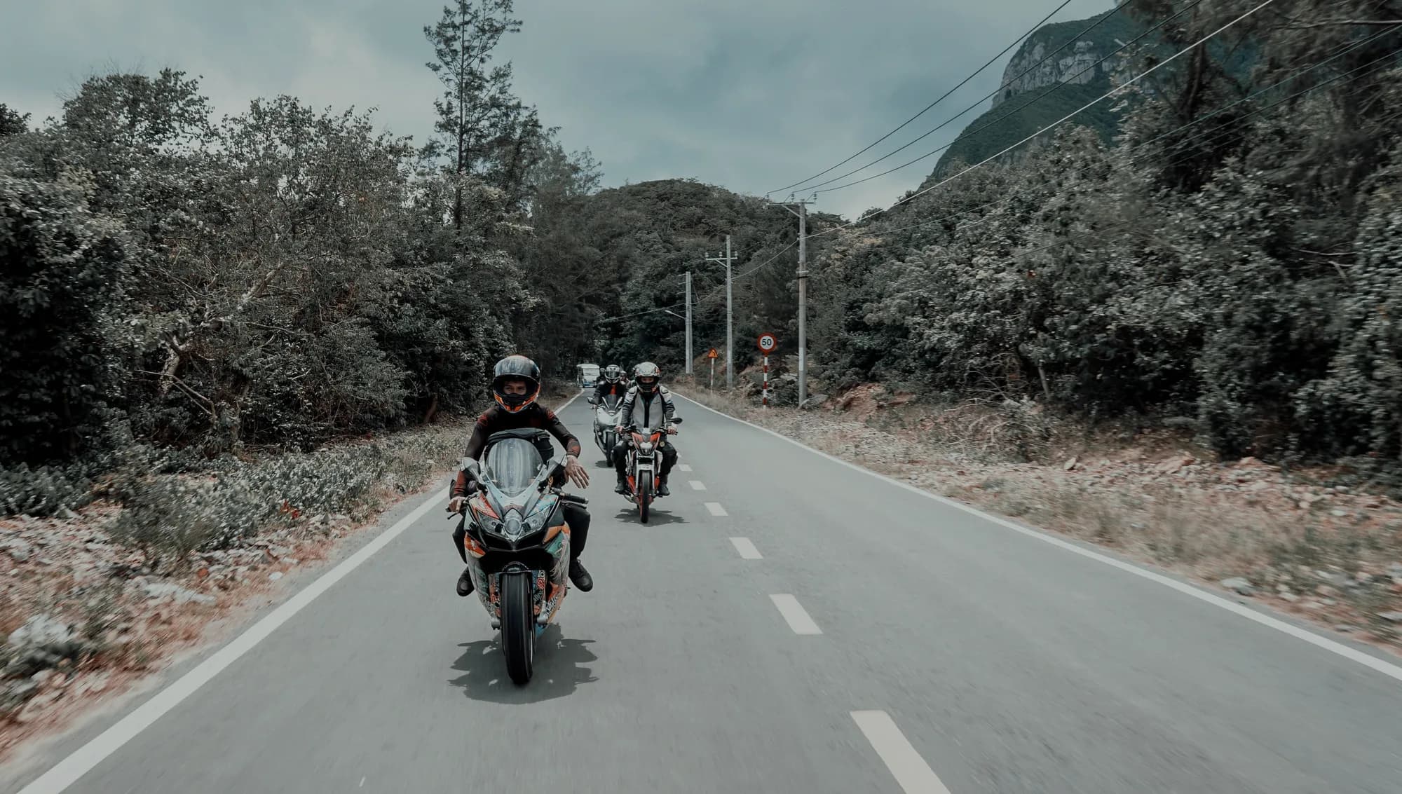 Comboio de motos em uma rodovia cercada por montanhas
